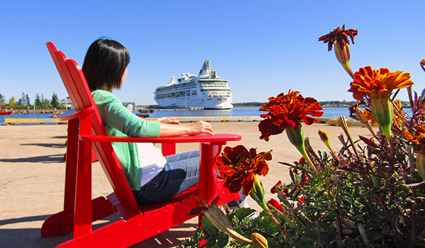 Woman sitting in a red chair at the Charlottetown port.