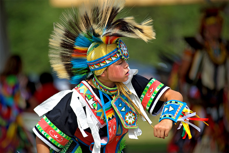 Indigenous person dressed up in traditional ceremonial clothing.