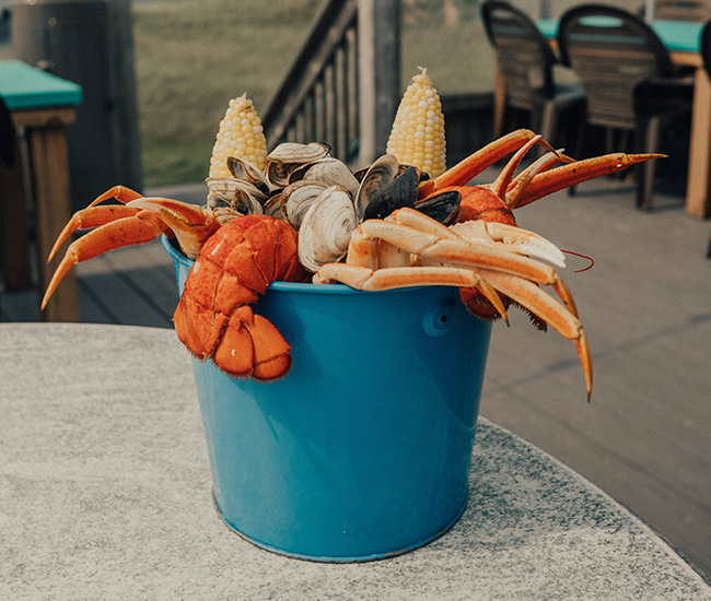 Bucket of fresh-cooked seafood and corn on the cob.